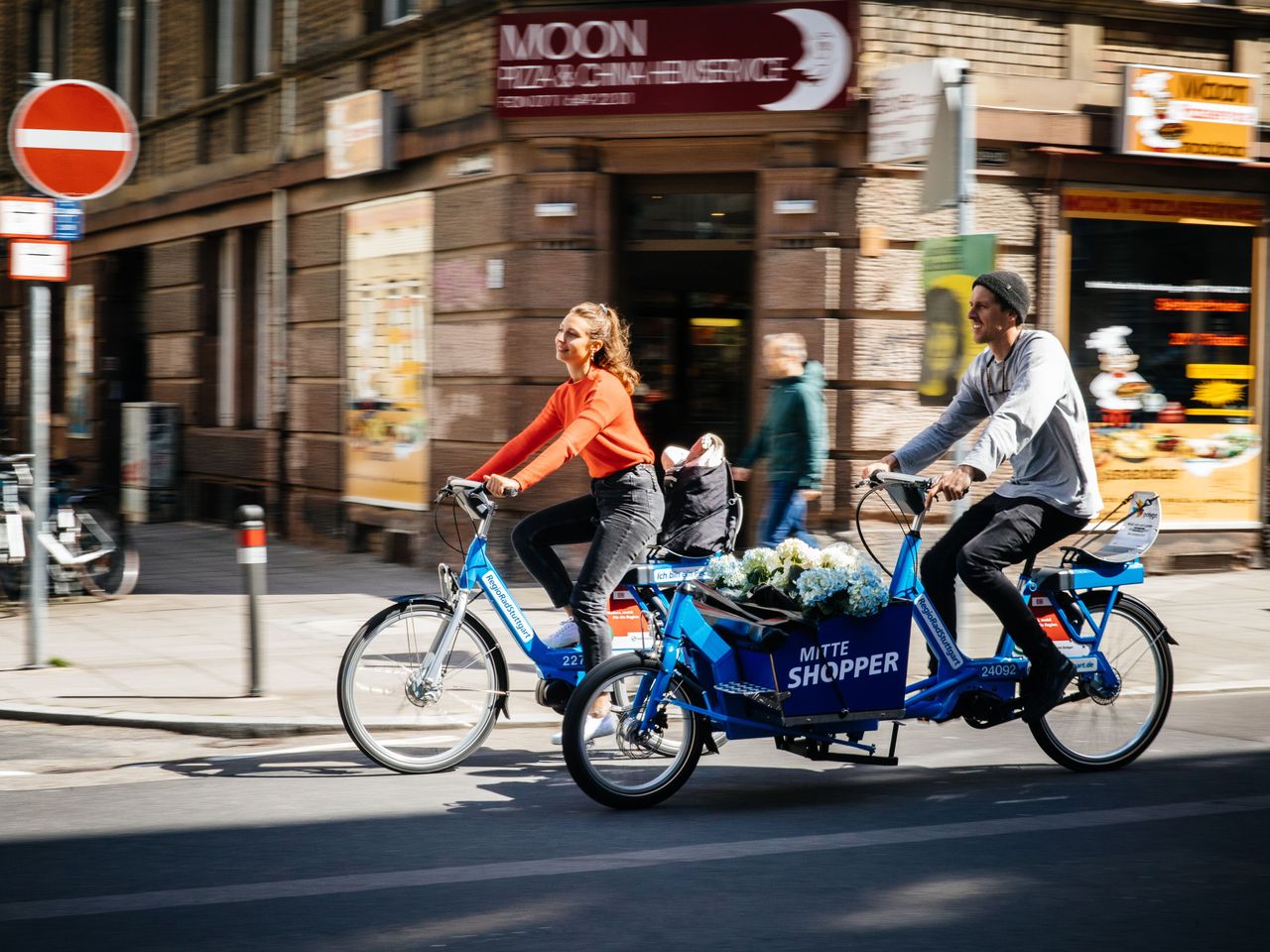 Man and woman ride through the city with RegioRadStuttgart pedelec and cargo pedelec 